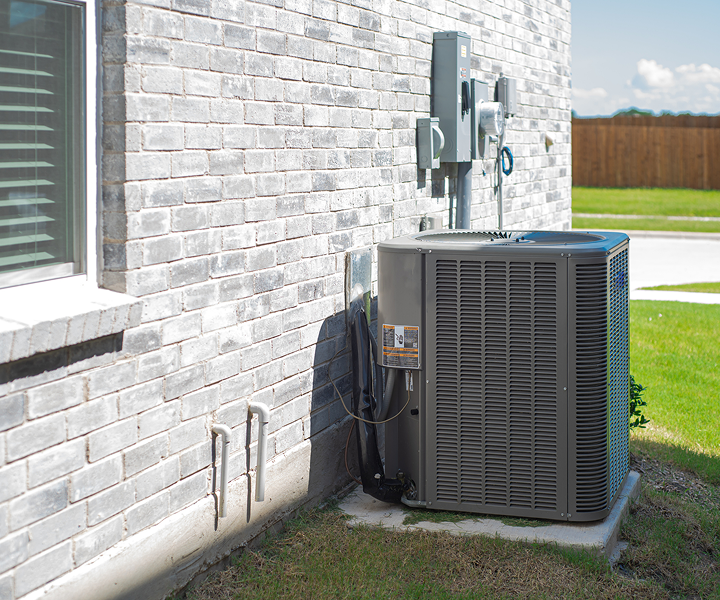 Outdoor air conditioning unit by brick wall