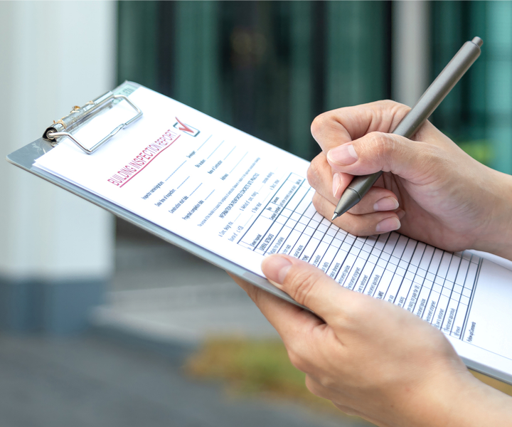 Person writing on a clipboard form