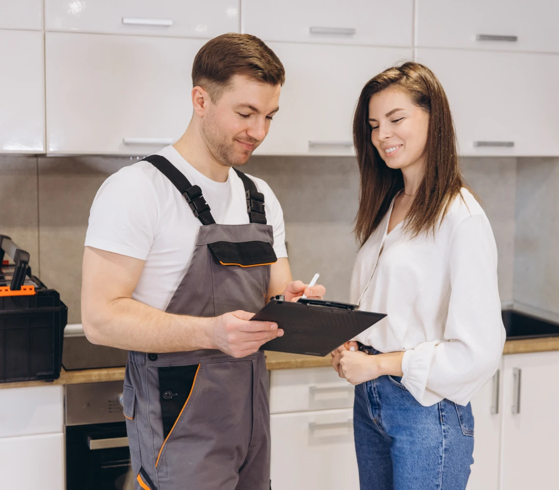 Repairman discussing with woman in kitchen