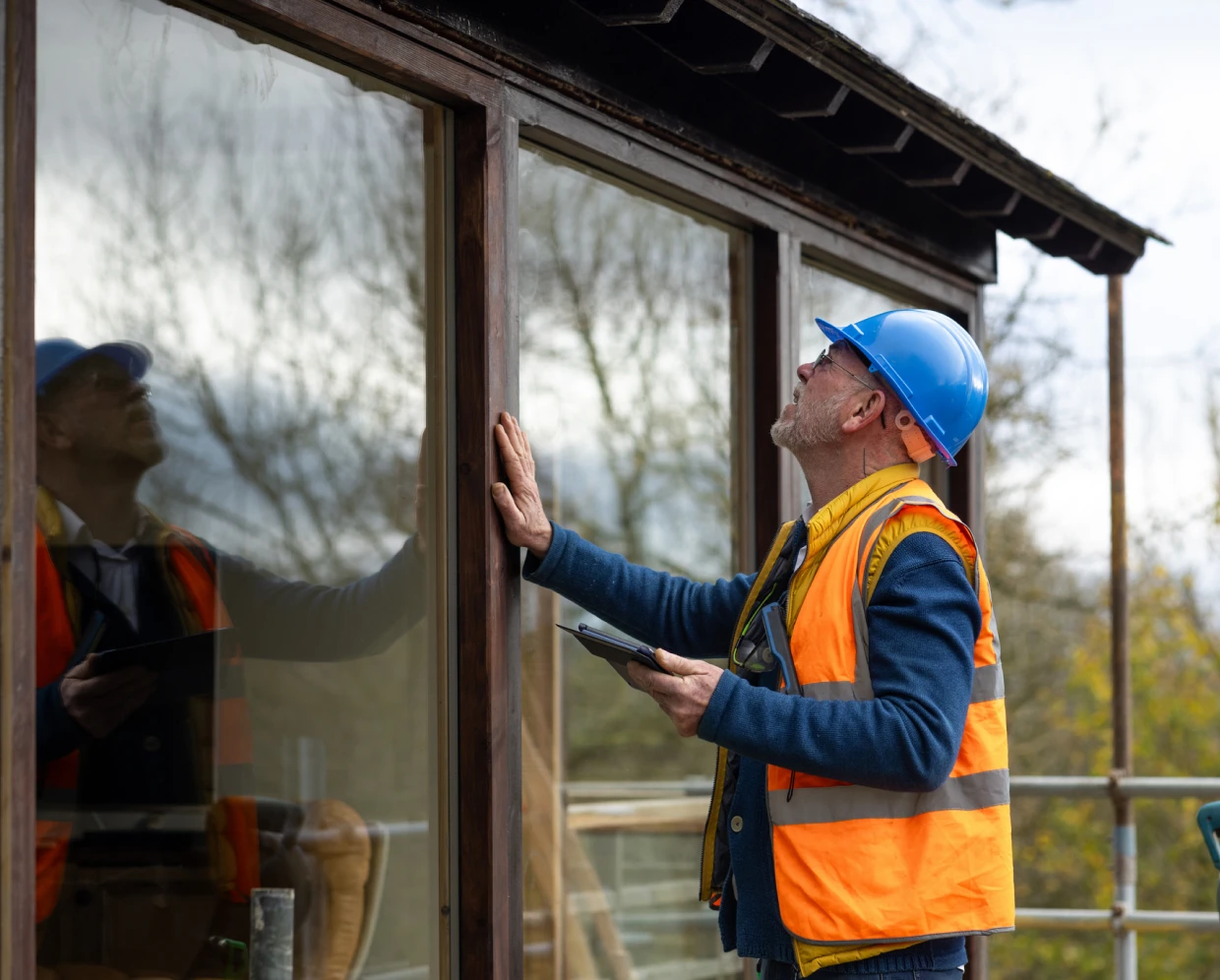 Man in hard hat examines glass panel