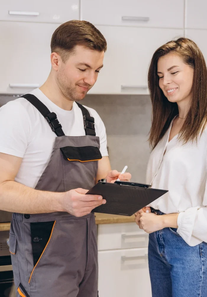 Repairman discussing with woman in kitchen